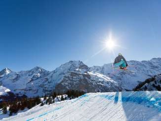 A skier on the ski cross course at the Mürren-Schilthorn ski resort. The Eiger, Mönch, and Jungfrau mountain trio can be seen in the distance.