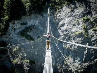 On the Mürren via ferrata, a climber crosses the suspension bridge toward Gimmelwald. The via ferrata in Mürren offers pure adrenaline.