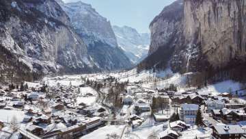 Drone shot of the village of Lauterbrunnen in winter, featuring the church and the Staubbchfall.
