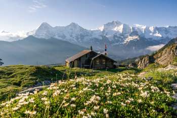 The Lobhorn Hut in spring, with the Eiger, Mönch, and Jungfrau in the background.
