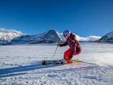 Le ski dans le domaine skiable de Grindelwald-Wengen. Les skieurs tracent de magnifiques virages dans la neige. En arrière-plan, on aperçoit le trio de sommets formé par l'Eiger, le Mönch et la Jungfrau.