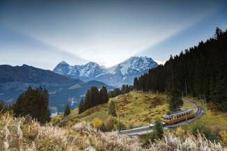 Fall Trip: The Lauterbrunnen-Mürren Mountain Railway (BLM) traveling between Mürren and Grütschalp. In the background, the trio of the Eiger, Mönch, and Jungfrau.