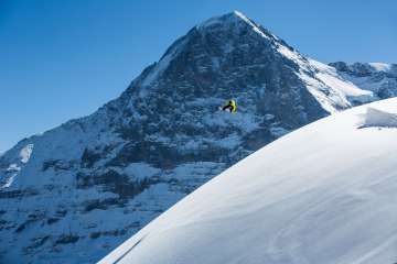 Snowboarden im Skigebiet Grindelwald-First. Jumps im frischen Pulverschnee vor dem Eiger.