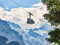 The LWM gondola with the Royal Ride on its roof. In the background, the snow-covered mountain panorama.