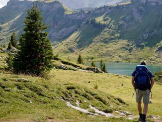 Hikers on their way to Sulsseeli above the Lobhorn Hut. The alpine landscape, with its meadows, rocks, and striking mountain peaks, defines the scenery along the hiking trail.