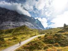 Rennradfahrer auf der Strasse zur Grossen Scheidegg mit Blick auf das Wetterhorn und alpine Landschaft.