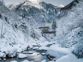 In winter, a Wengernalpbahn train crosses a bridge in Lauterbrunnen.