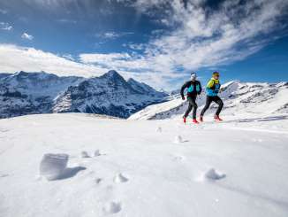 Two runners during the Winter Trail Running event at Grindelwald First, with the Eiger in the background.